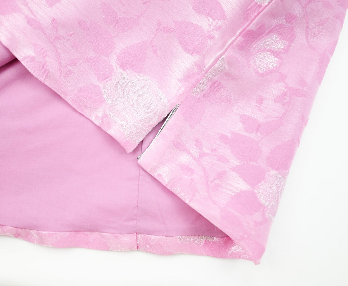 Pink textured fabric with a subtle pattern on a white background