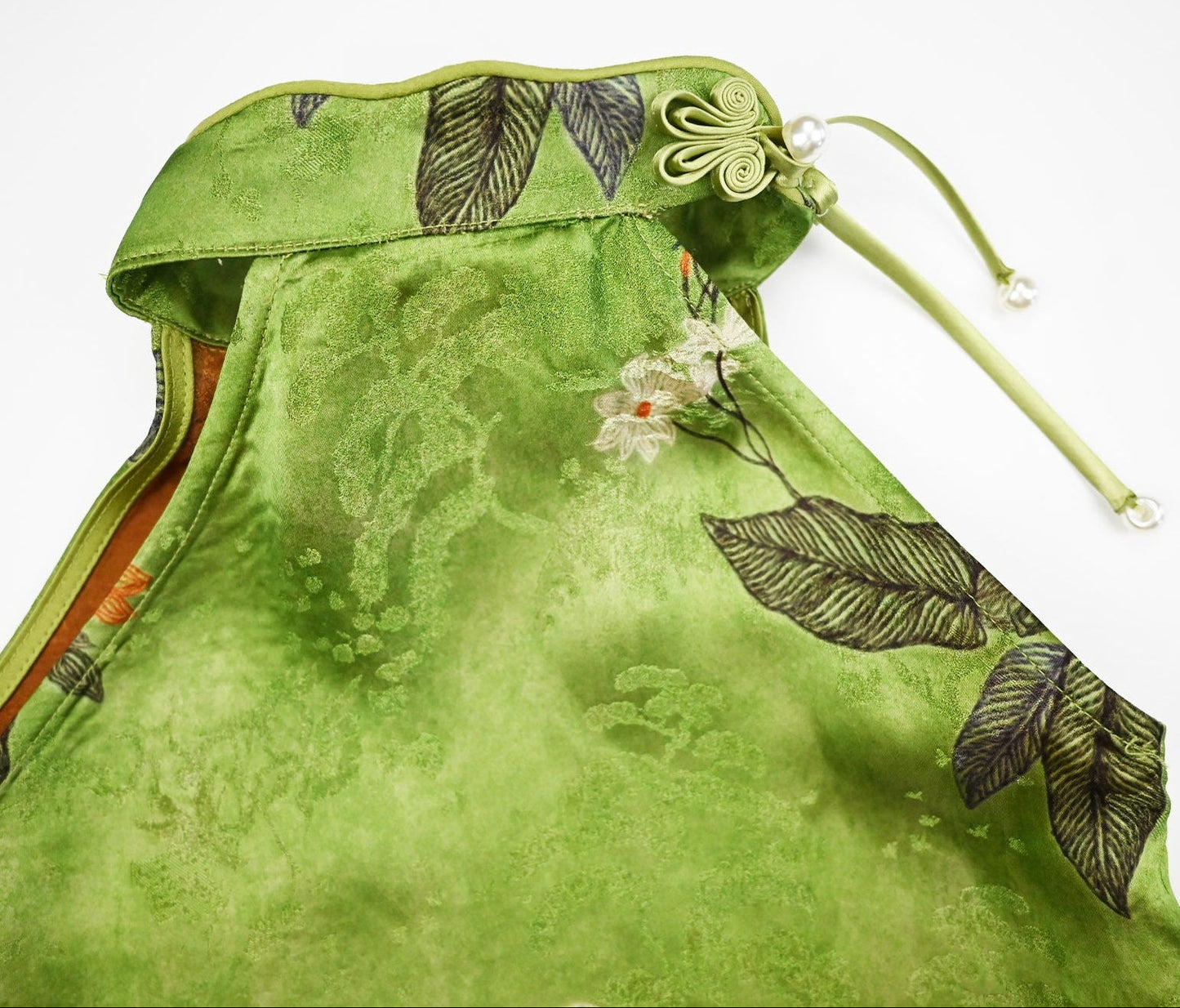 Green dress with floral and leaf patterns on a white background