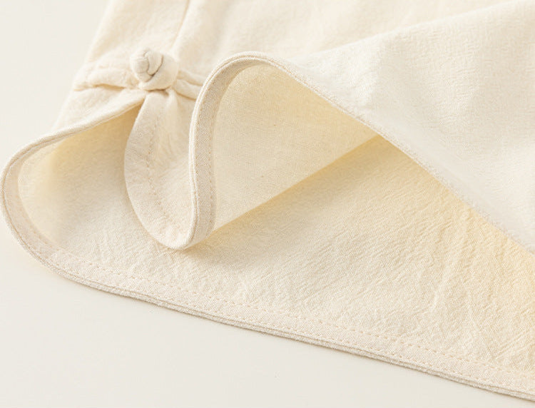 Close-up of a textured beige fabric with a bow on a light background