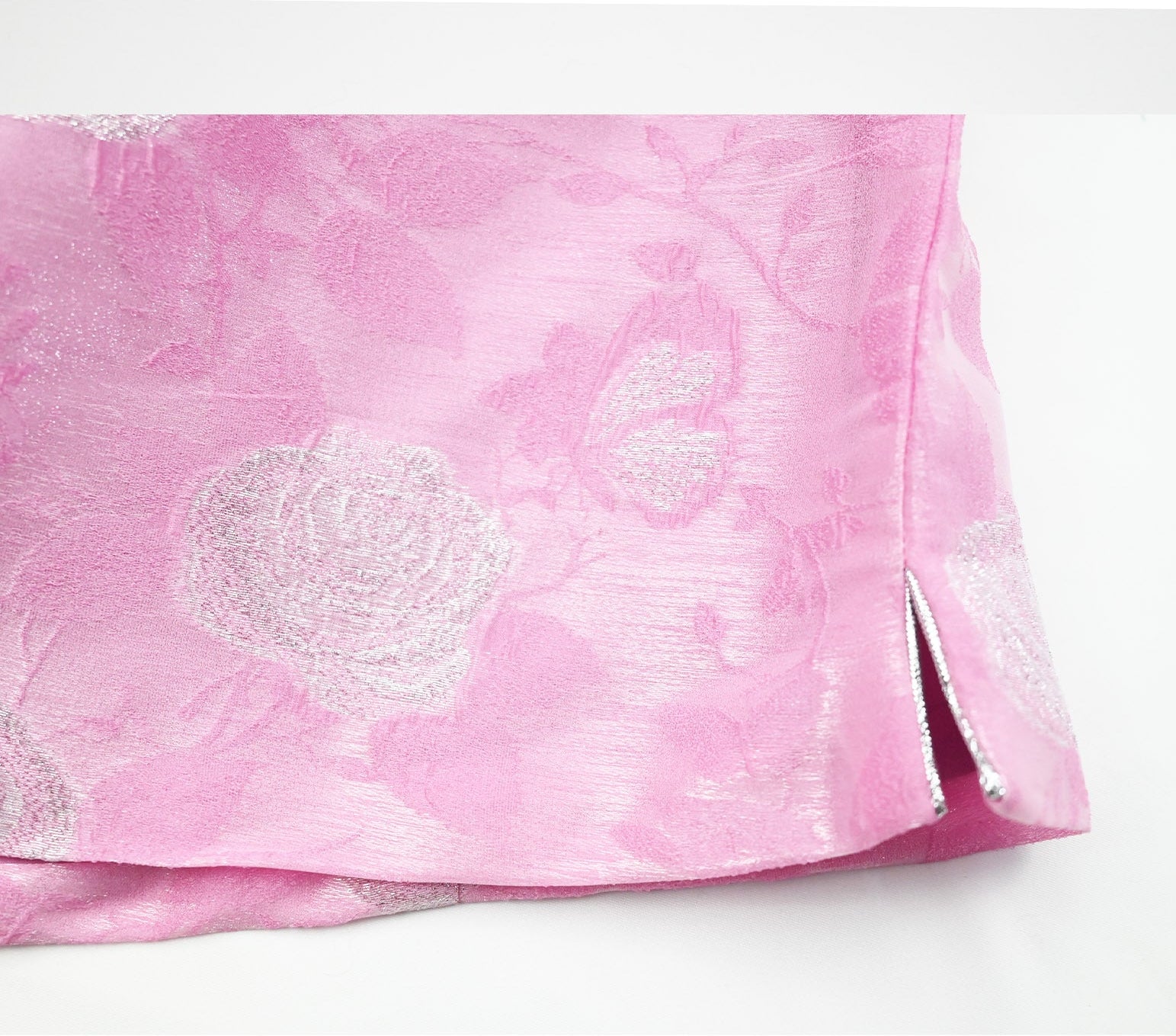 Pink fabric with silver floral pattern on a white background