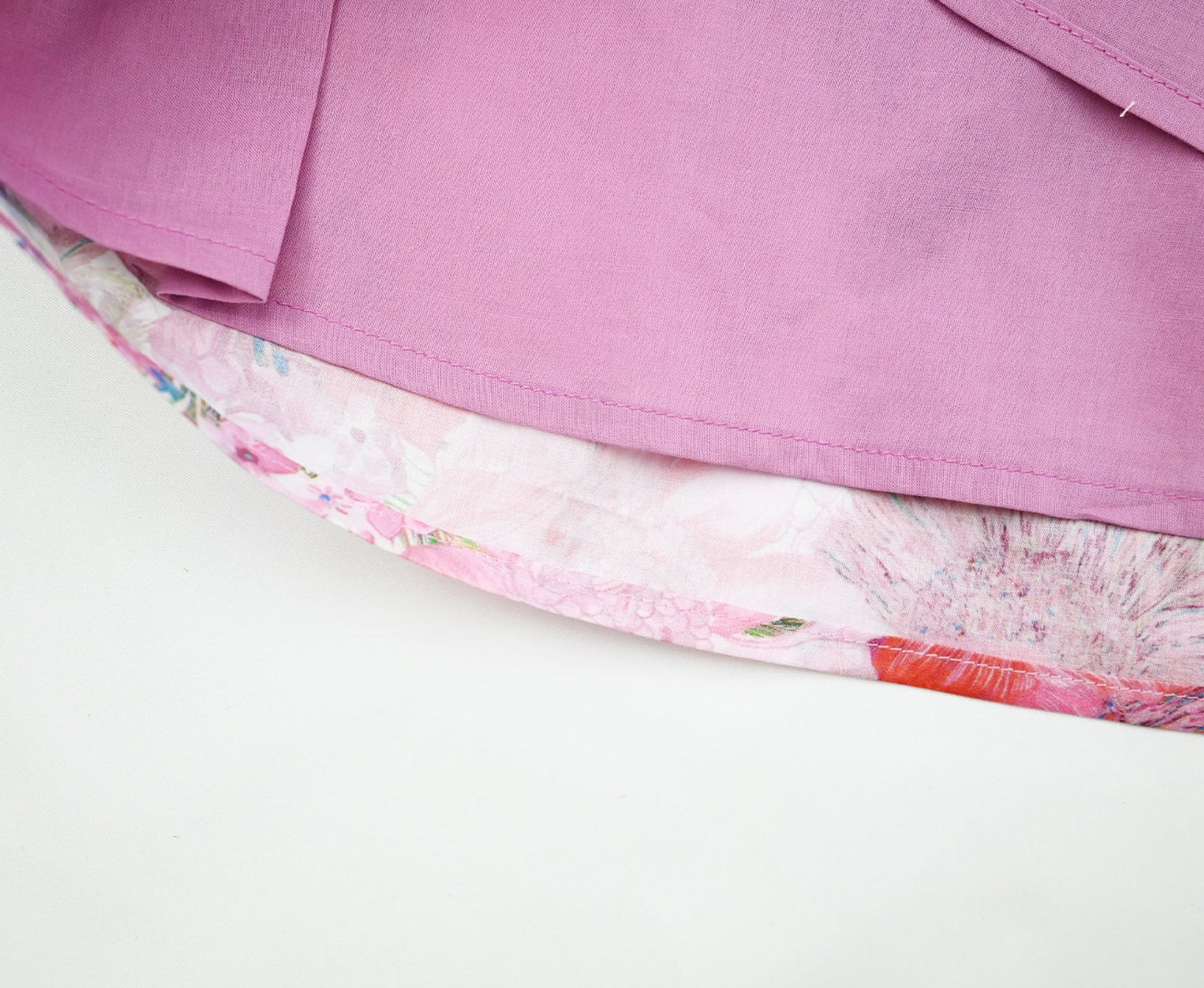 Close-up of a pink skirt with floral lining on a white background