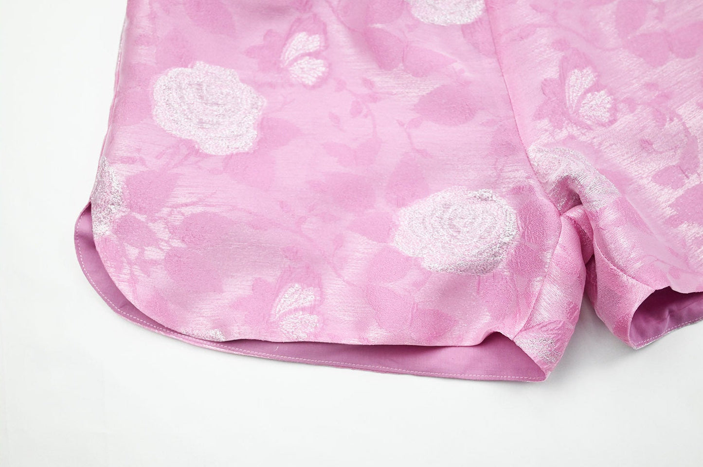 Pink fabric with white floral patterns on a white background