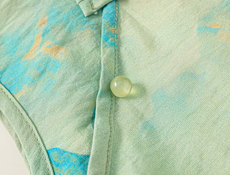 Close-up of a textured fabric with a button on a light green background